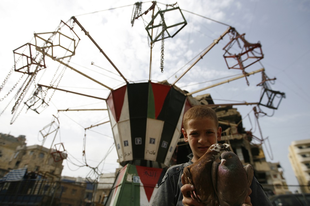 A Palestinian boy holds pigeons inside the Shatila refugee camp in Beirut